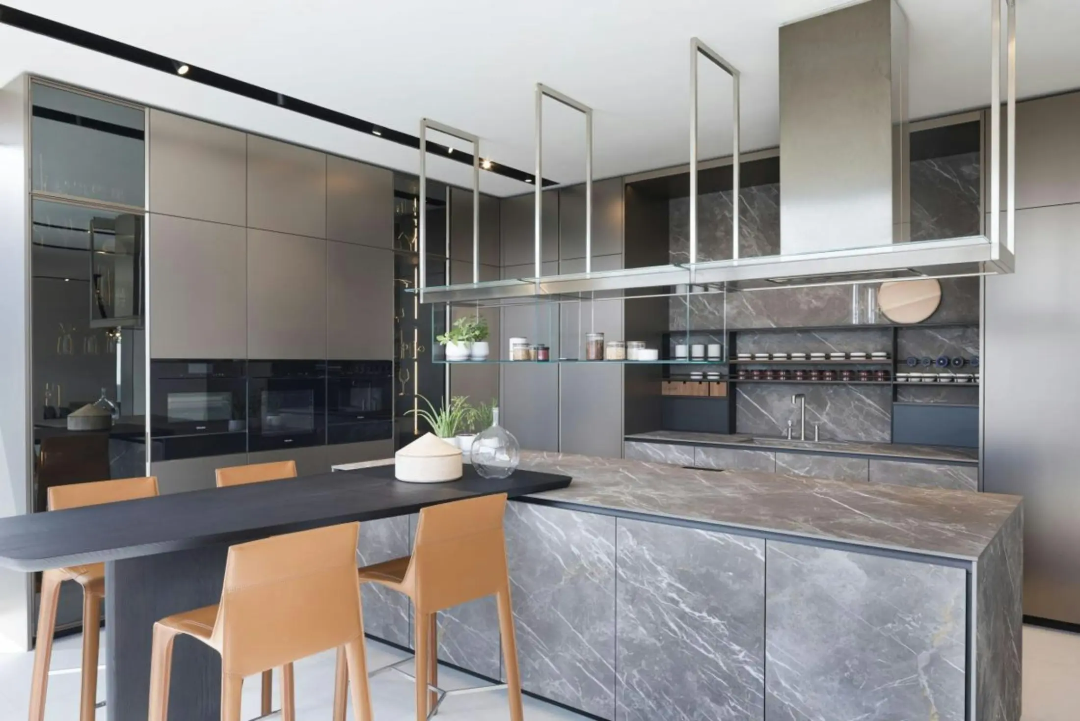 Luxury kitchen with book-matched grey stone, smoked glass cabinetry and bronze leather stools